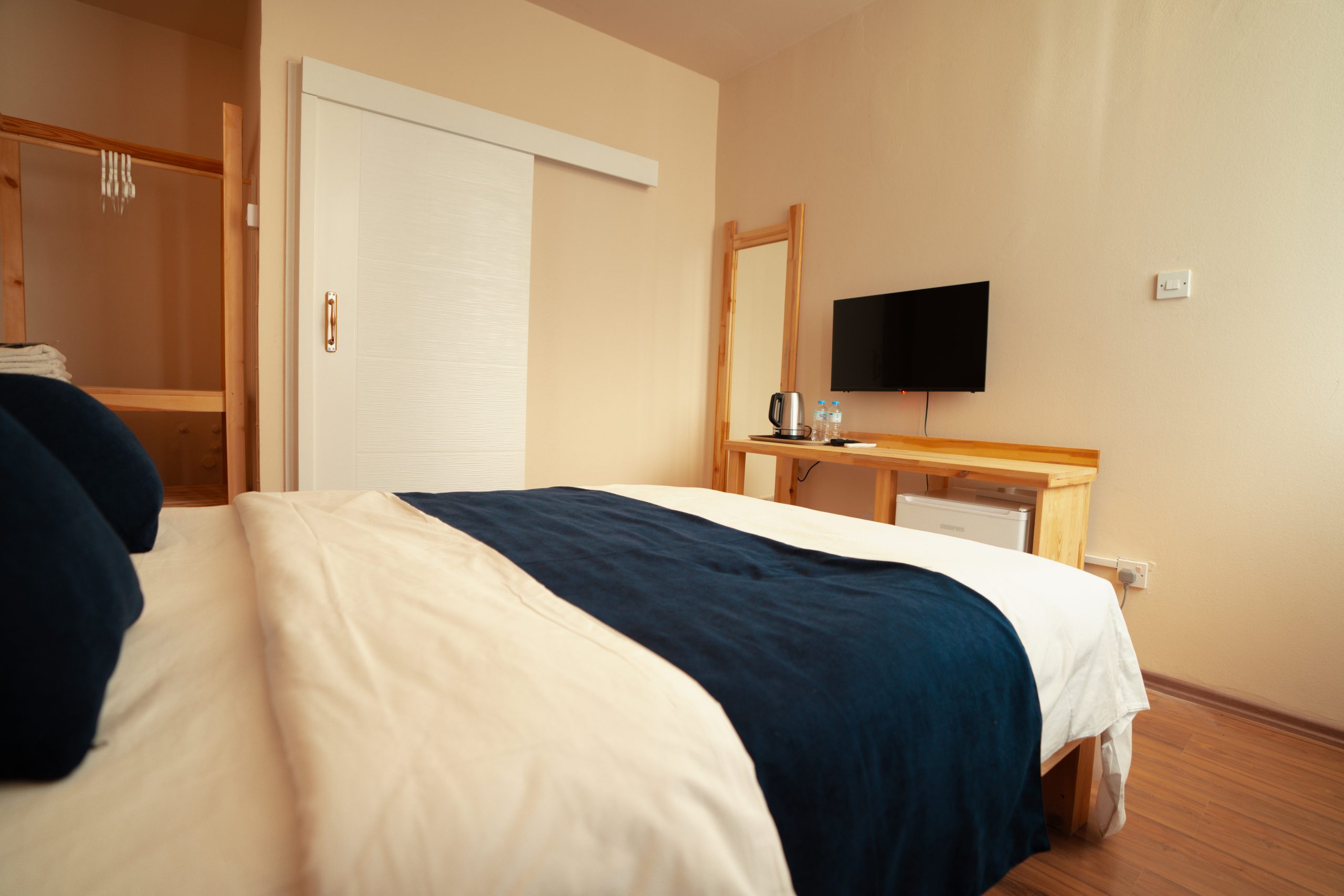 Double room interior with wooden headboard at Zuma Hotel
